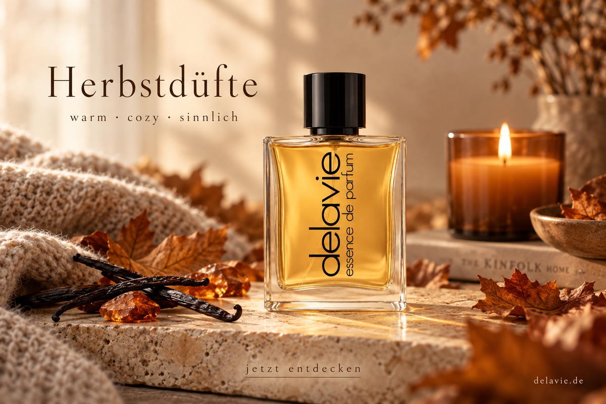 DELAVIE-Parfumflakon mit bernsteinfarbener Flüssigkeit, Herbstlaub und Vanilleschoten im warmen Kerzenlicht. Schriftzug: „Herbstdüfte – warm · cozy · sinnlich“.